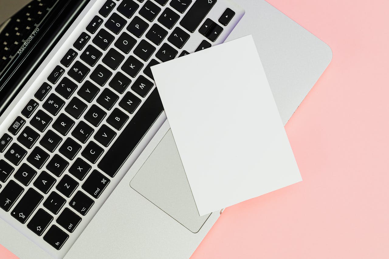 services-img A blank card placed on a laptop keyboard with ample copy space on a pastel background.